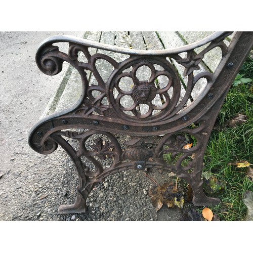 1326 - A cast iron garden bench with lion head design panels, 148cms w x 60cms d x 85cms h.