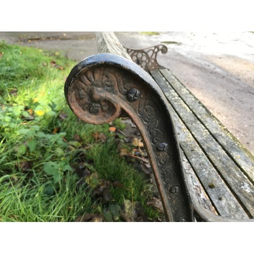 1326 - A cast iron garden bench with lion head design panels, 148cms w x 60cms d x 85cms h.