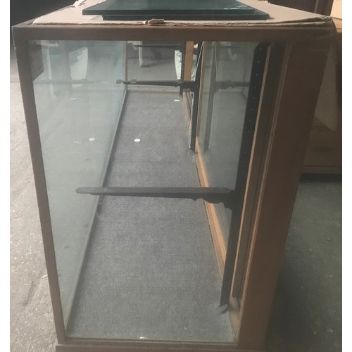 1286 - A large oak framed shop counter display cabinet, all sides glass, sliding doors with shelf bracket a... 