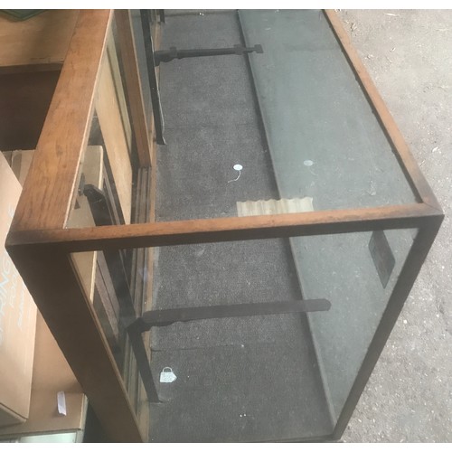 1286 - A large oak framed shop counter display cabinet, all sides glass, sliding doors with shelf bracket a... 