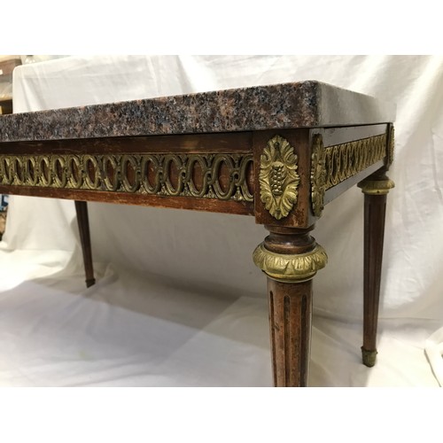 1283 - A granite topped side table with decorative brass to sides and Corinthian column legs. 90cms w x 50c... 