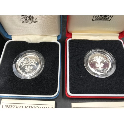 604 - Royal Mint silver proof coins : 2009 UK Shield of the Royal Arms £1 coin and two silver £1 coins, 19... 