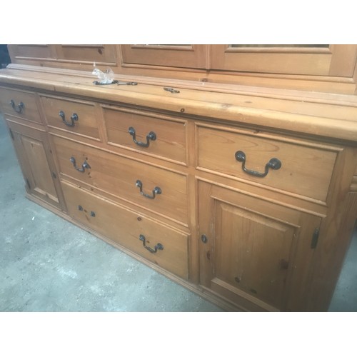 1303 - A large pine wall unit with glazed door top, sideboard base, six drawer, two cupboard. 180cms W x 49... 