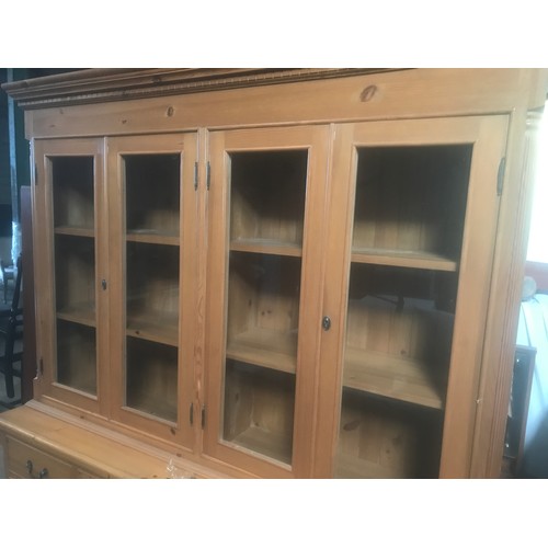 1303 - A large pine wall unit with glazed door top, sideboard base, six drawer, two cupboard. 180cms W x 49... 