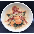 A Moorcroft wall charger decorated with birds and fruit 26.5cms d and impressed base marks.