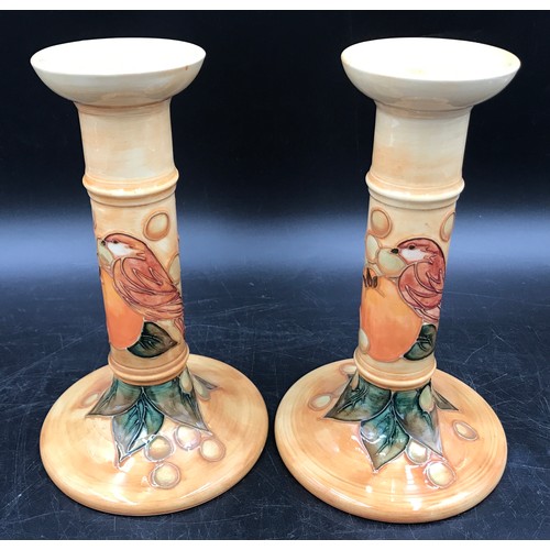 19 - A Moorcroft pair of candle sticks decorated with birds and fruit 20.5cms h and impressed base marks.