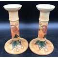 A Moorcroft pair of candle sticks decorated with birds and fruit 20.5cms h and impressed base marks.