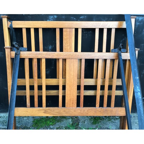 1296 - An oak double bed, slat back head board and base with iron bars. 138cm w x 189cm l.