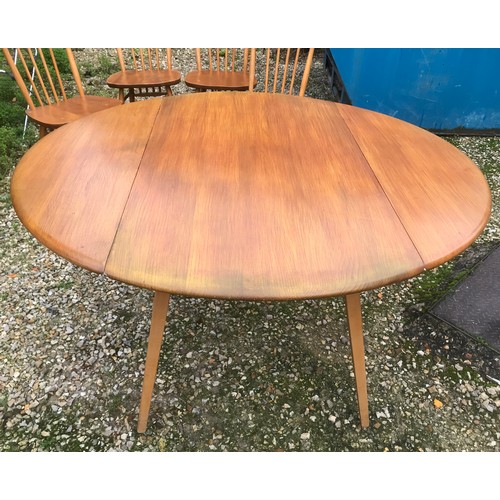 1318 - An Ercol oval drop leaf table with blue label. 113cm x 125cm open, 72cm h together with 4 stick back... 