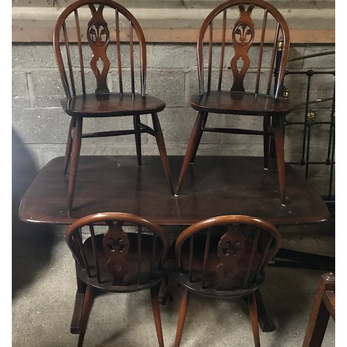 1205B - An Ercol refectory dark wood dining table and 4 stick back dining chairs. Table 138 w x 77 d x 72cms... 