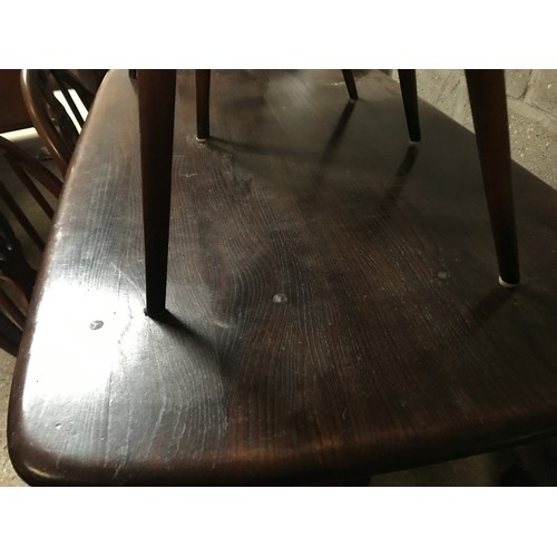 1205B - An Ercol refectory dark wood dining table and 4 stick back dining chairs. Table 138 w x 77 d x 72cms... 