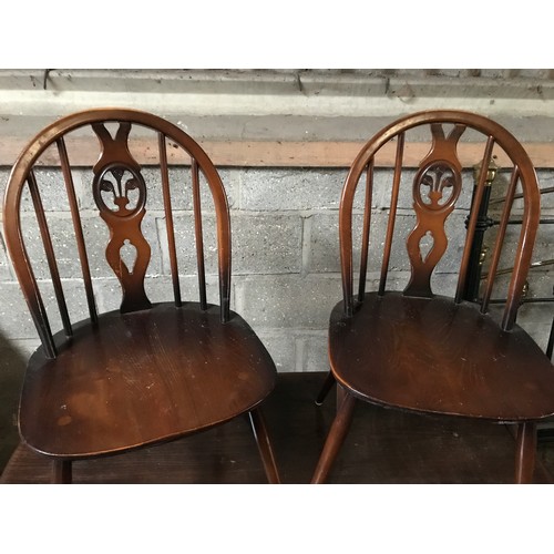 1205B - An Ercol refectory dark wood dining table and 4 stick back dining chairs. Table 138 w x 77 d x 72cms... 