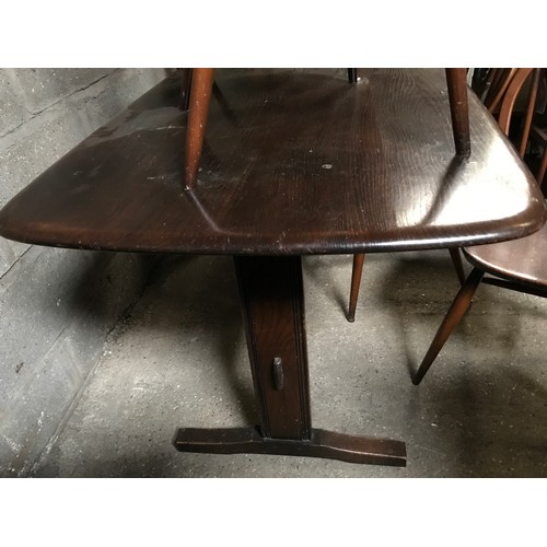 1205B - An Ercol refectory dark wood dining table and 4 stick back dining chairs. Table 138 w x 77 d x 72cms... 