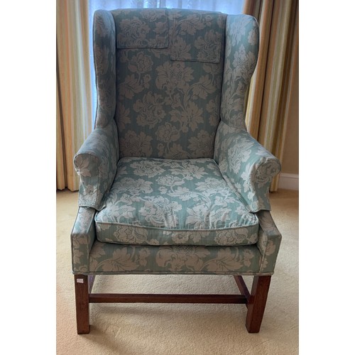 1240 - A wing backed upholstered armchair.