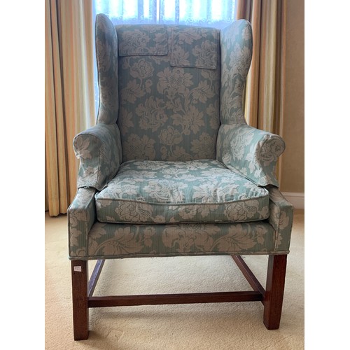 1240 - A wing backed upholstered armchair.