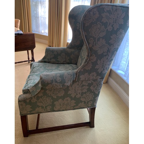 1240 - A wing backed upholstered armchair.