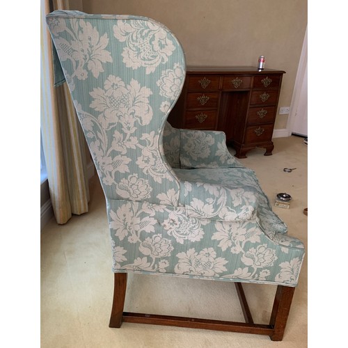 1240 - A wing backed upholstered armchair.