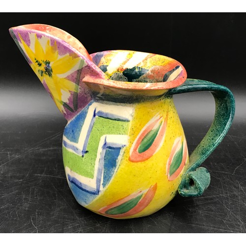 194 - Paul Jackson studio pottery jug in a multi coloured abstract design. Signed to base c2000. 16cm h.