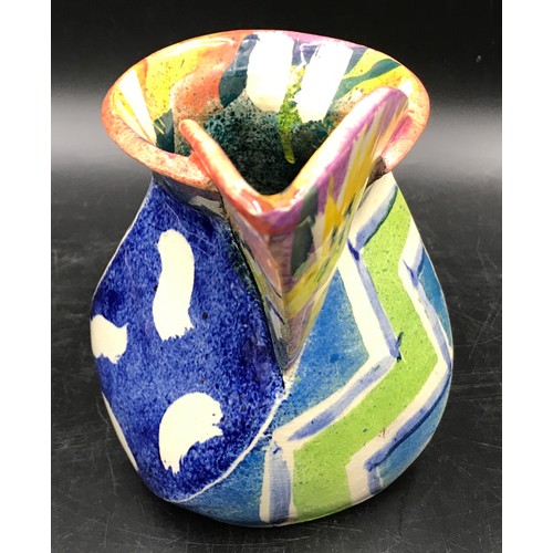 194 - Paul Jackson studio pottery jug in a multi coloured abstract design. Signed to base c2000. 16cm h.