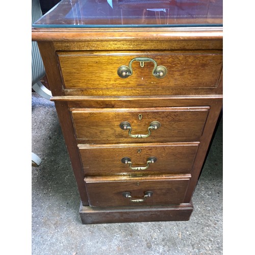 1263 - A mahogany kneehole desk with leather and glass top. 152 w x 90 x 77cm h.