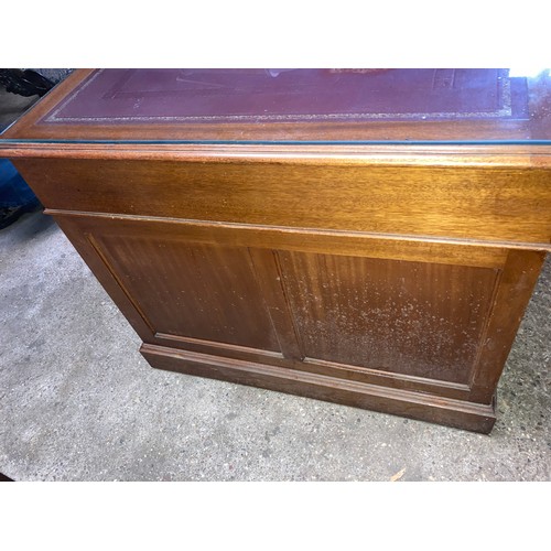 1263 - A mahogany kneehole desk with leather and glass top. 152 w x 90 x 77cm h.