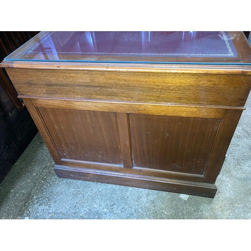 1263 - A mahogany kneehole desk with leather and glass top. 152 w x 90 x 77cm h.