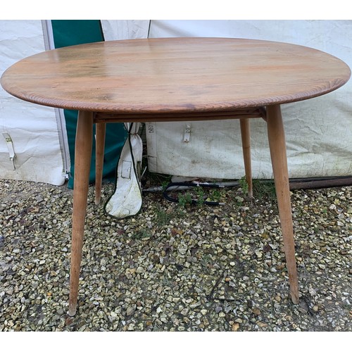 1265 - An Ercol oval topped dining table with under rack shelf and blue label. Top 99 x 89 x 73cm h