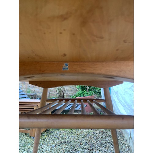 1265 - An Ercol oval topped dining table with under rack shelf and blue label. Top 99 x 89 x 73cm h