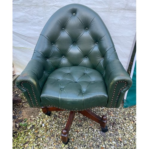 1266 - A green leather button back swivel tub armchair. Height to seat 48cm, to back 98cm, width 76cm.