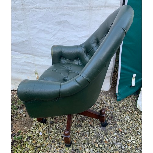 1266 - A green leather button back swivel tub armchair. Height to seat 48cm, to back 98cm, width 76cm.