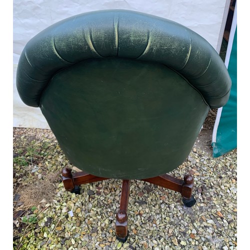 1266 - A green leather button back swivel tub armchair. Height to seat 48cm, to back 98cm, width 76cm.