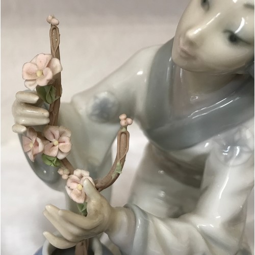 84 - Two  Lladro figurines, a Japanese girl arranging cherry blossom 19 h x 12 w x 16 at base and a wizar... 