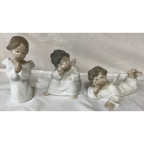 86 - Three Lladro angel figurines, kneeling 14cm, sitting 11cm and laid 7cm.