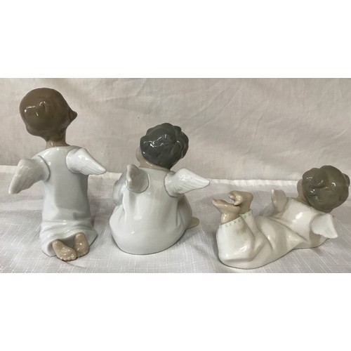 86 - Three Lladro angel figurines, kneeling 14cm, sitting 11cm and laid 7cm.