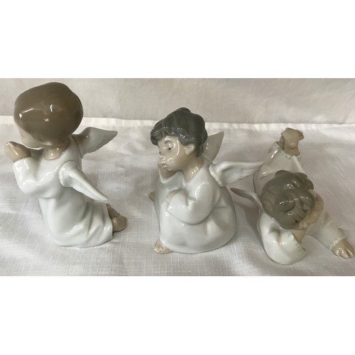 86 - Three Lladro angel figurines, kneeling 14cm, sitting 11cm and laid 7cm.