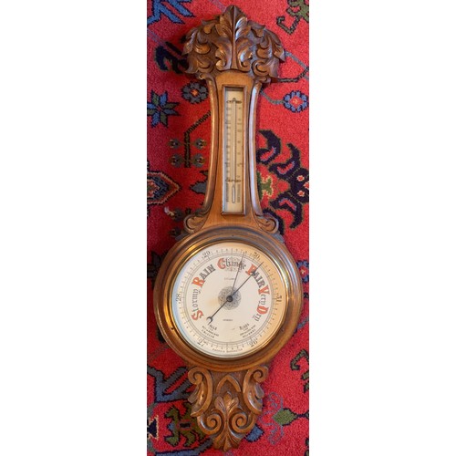 647 - A finely carved light oak aneroid barometer. E. F. Lundy, Grimsby. 87cm h.