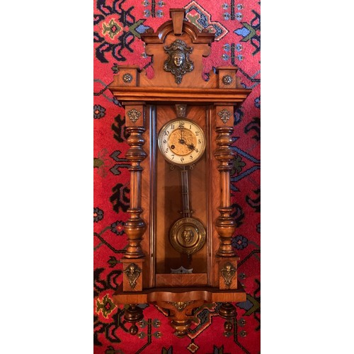 653 - A Victorian walnut chiming wall clock with gilt and enamel dial. 100cm.