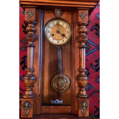 653 - A Victorian walnut chiming wall clock with gilt and enamel dial. 100cm.