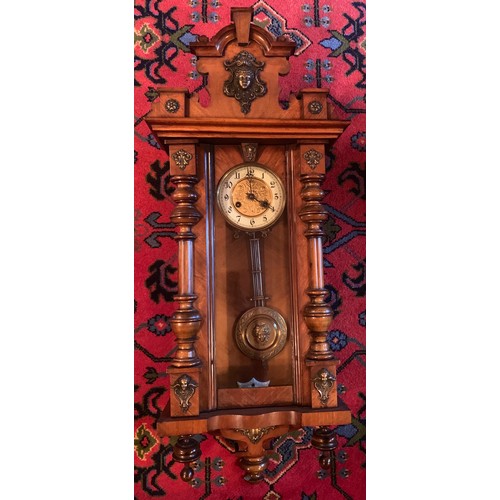 653 - A Victorian walnut chiming wall clock with gilt and enamel dial. 100cm.