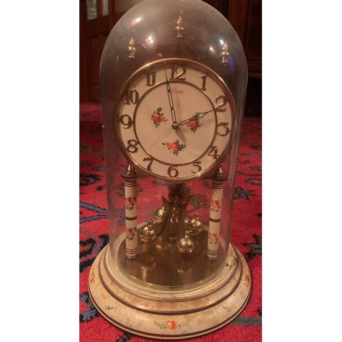 655 - A Kundo anniversary clock in glass dome. 32cm h.