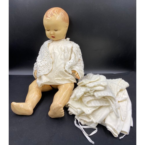 762 - A vintage celluloid doll with unassociated doll's clothes. length 62cm.