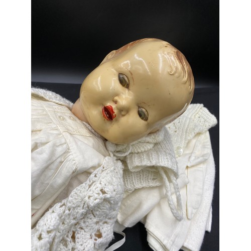 762 - A vintage celluloid doll with unassociated doll's clothes. length 62cm.