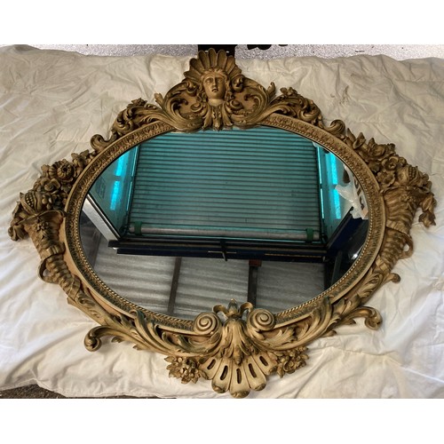 1191 - An ornate Italian style oval mirror. 117 w x 103cm.