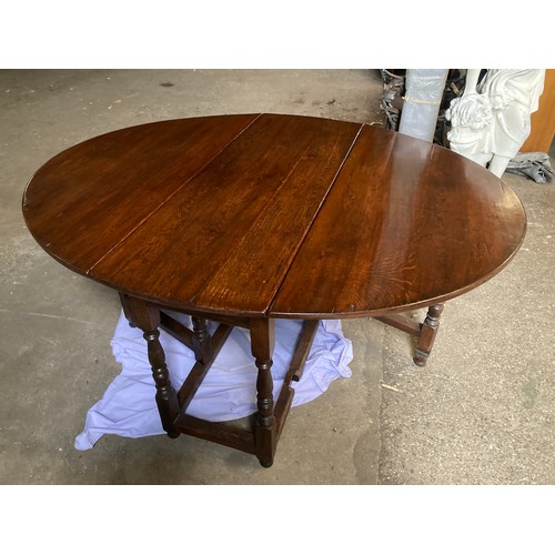 1193 - An oak gateleg dining table 150 w x 122cm open, closed 46 x 75cm h.