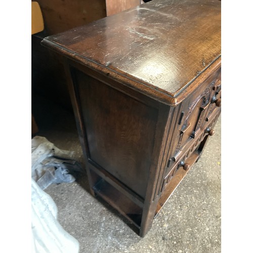 1195 - A carved oak cabinet, 2 doors over single drawer 69 w x 38 x 82cm h. Label to back. G T Rackstraw Lt... 