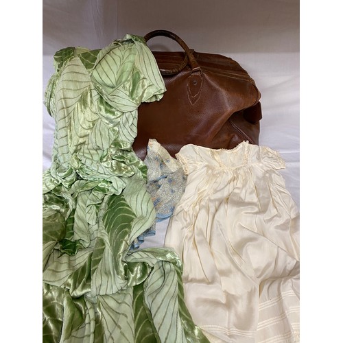 498 - A vintage brown leather suitcase contents to include a 1930's silk velvet bias cut green dress. Peti... 