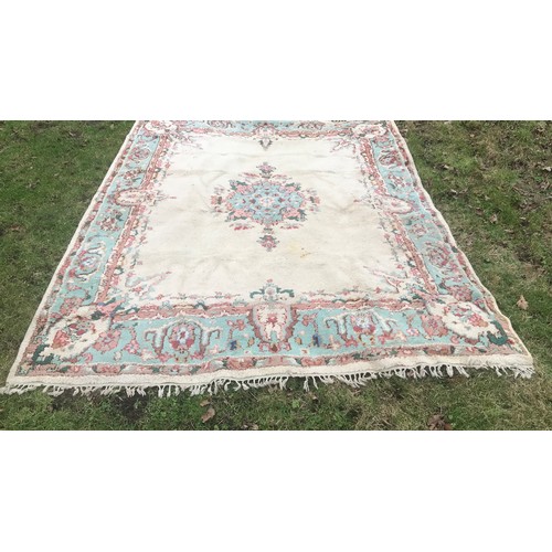 513 - Large floral patterned wool rug, cream panel with blue border. 265 x 221cm.