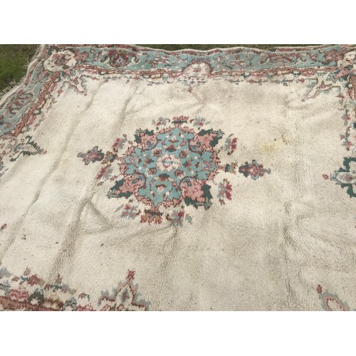 513 - Large floral patterned wool rug, cream panel with blue border. 265 x 221cm.