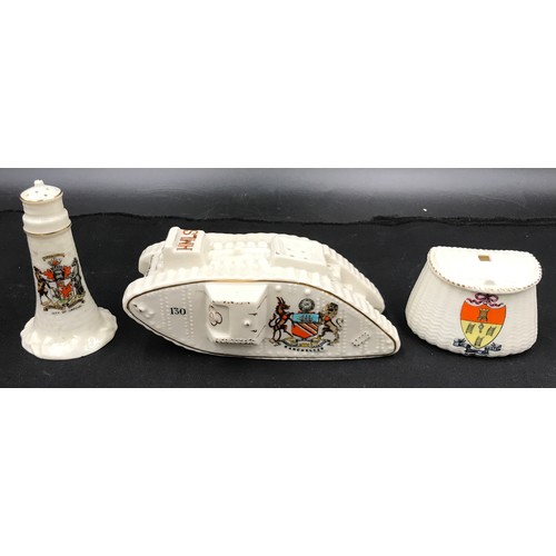 179 - A crested ware WWI tank with Manchester crest 16cm l, lighthouse Cardiff 10 cm h and a fishing baske... 