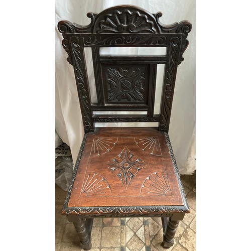 1200 - A carved oak hall chair, height to seat 46cm x back 100cm, width 46cm.